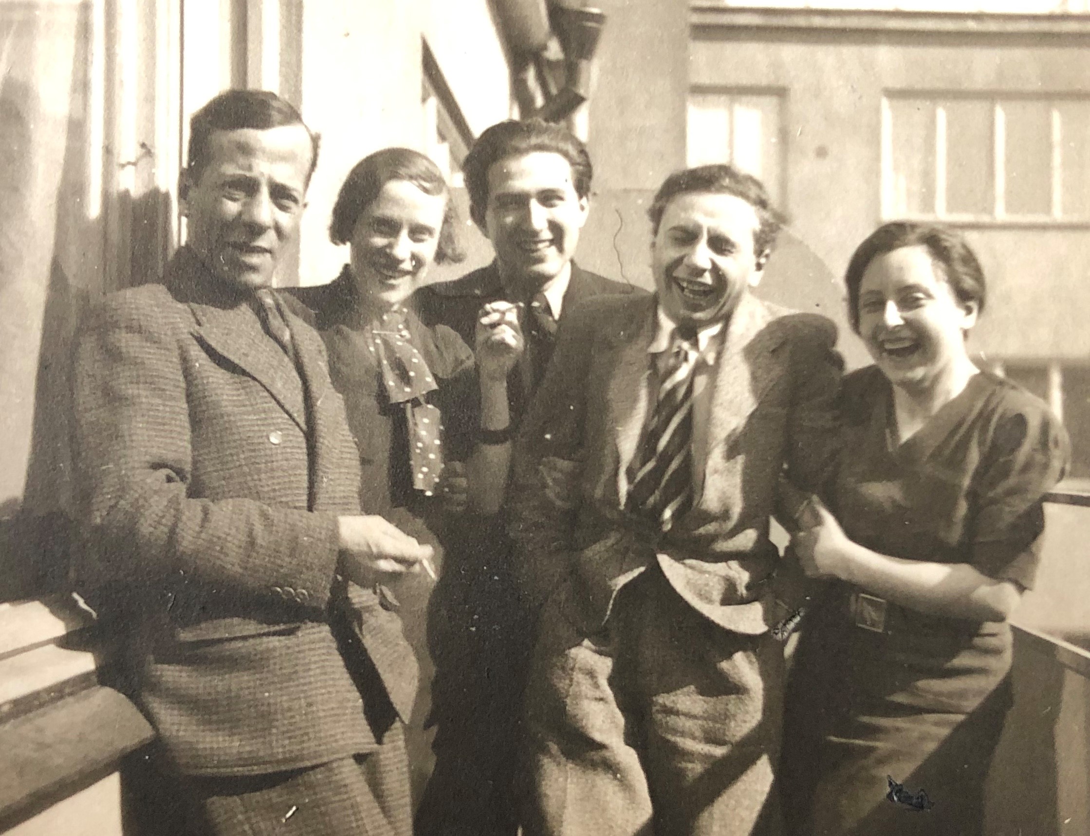 Fem personer står nära varandra och ser ut att vara vänner. Fyra av dem skrattar, men den femte ser alvarlig ut. Det är Erich Holewa.